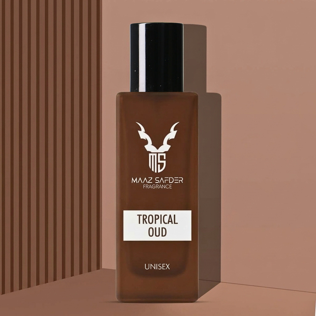 A brown rectangular fragrance bottle with a black cap and white printed label reading 'MAAZ SAFDER FRAGRANCE', 'TROPICAL OUD', and 'UNISEX', shown on a warm beige background with vertical brown stripes on the left.